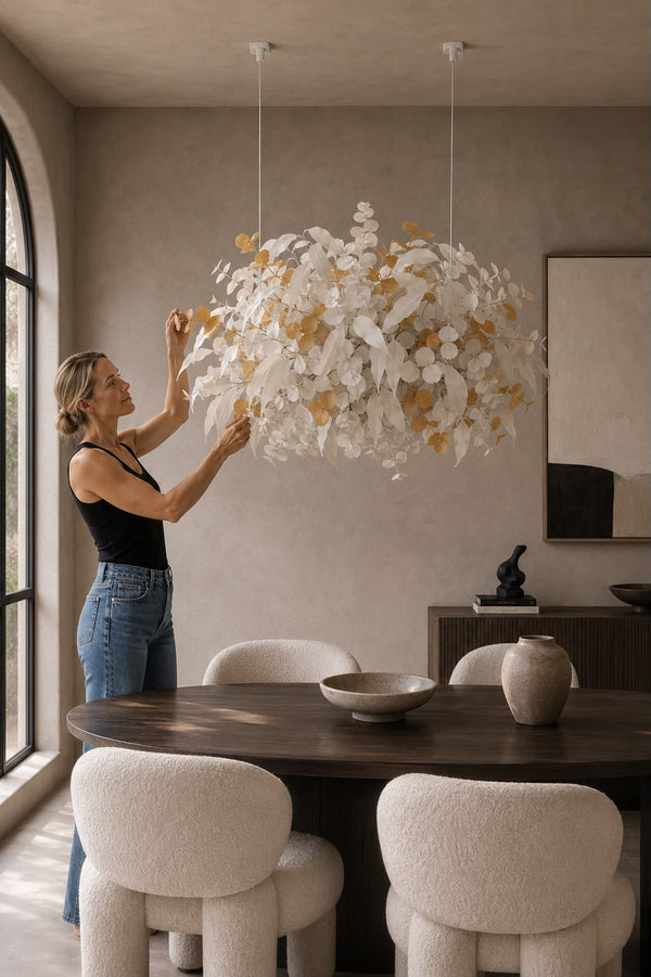 Nube Botánica de eucalipto blanco y dorado colgada del techo sobre una mesa de comedor