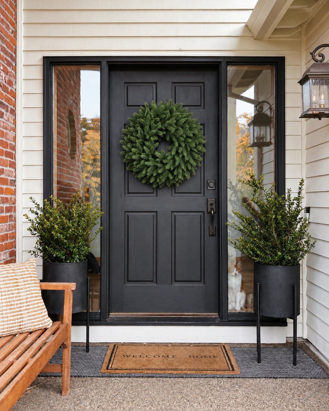 Corona de Navidad Alpino verde de 60 cm colgada en una puerta negra de entrada