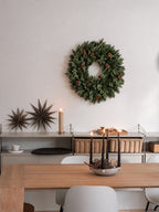 Corona de Navidad balsámica con piñas en la pared de un comedor · BOSSVI