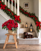 Escalera con tres guirnaldas balsámicas Maxi, cinta y lazos rojos de terciopelo y poinsettia en cesta de ratán · BOSSVI